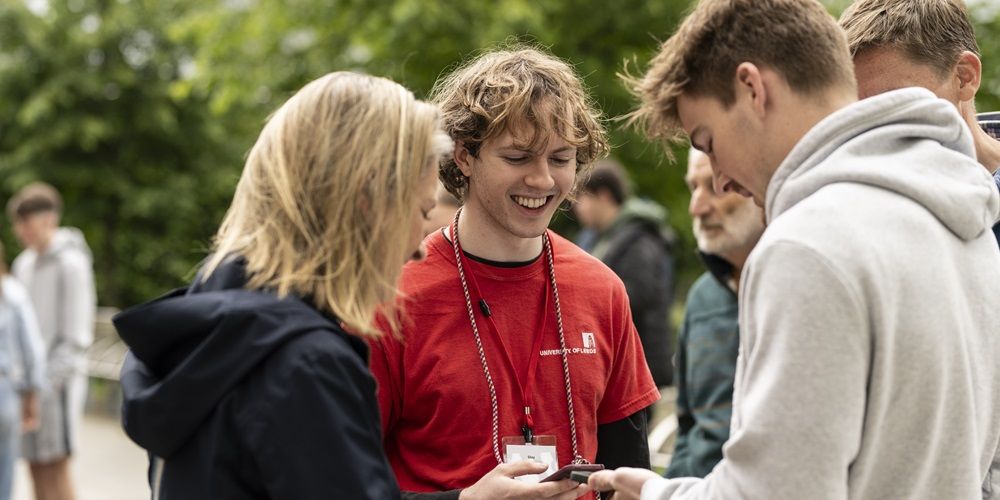 Visitors talking to a student ambassador on campus at open day.