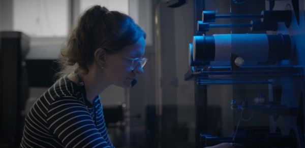 A person working with a textile durability testing machine.