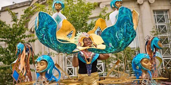 Woman wearing cold and turquoise carnival costume with Afrofuturism theme