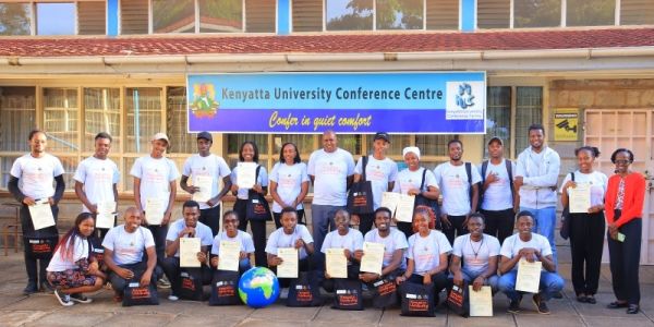 A large group of people are holding up their certificates for participating in the Kenyatta University hackathon.