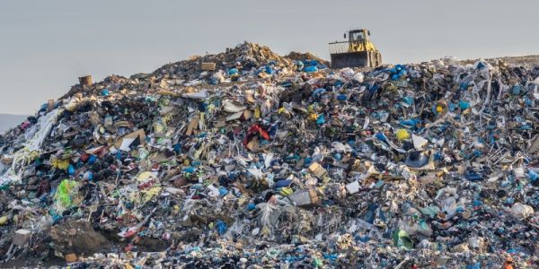 huge pile of waste, with a bulldozer on top