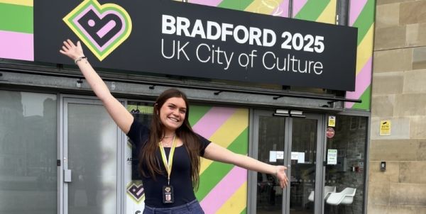 Evie outside a building with a Bradford 2025 sign.