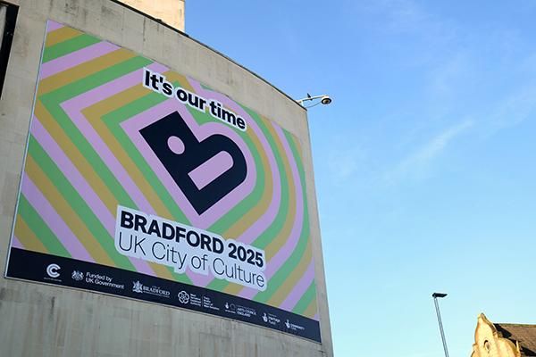 Bradford 2025 poster displayed on the side of a building, with blue skies in the background