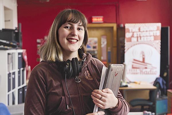 Carys gwenllian hind at Leeds Student Radio, smiling in a studio.