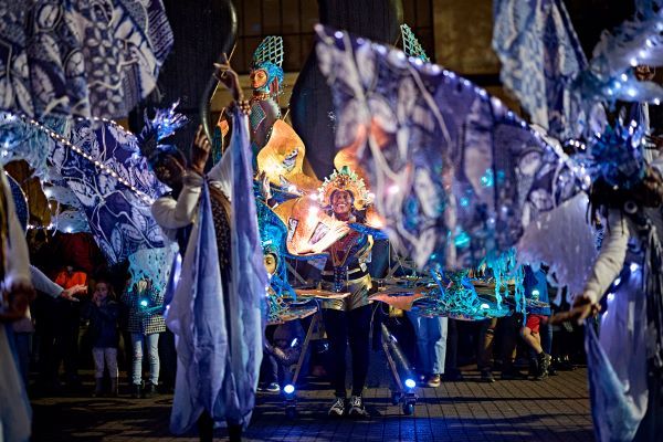 A group of performers wearing multisensory, colourful, illuminated costumes.