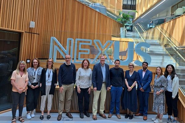 A large group of researchers and staff in the foyer of Nexus