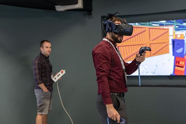 Two people using the omnideck in Helix. One is wearing a VR headset.