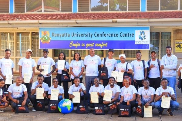 A large group of people are holding up their certificates for participating in the Kenyatta University hackathon.