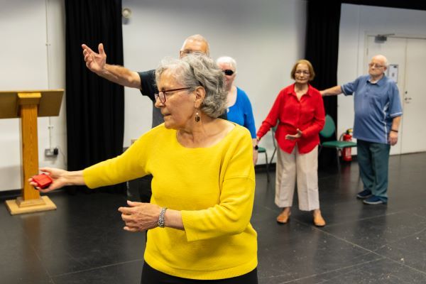 A group of older people taking part in a dance or movement activity.