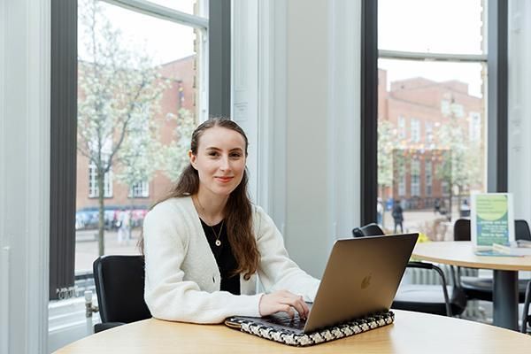 Student Katharine Charlton sitting at a desk using a laptop.