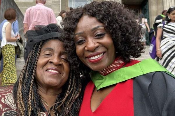 Graduate Memory Moyo in her gowns, pictured with her mother on the famous Parkinson steps