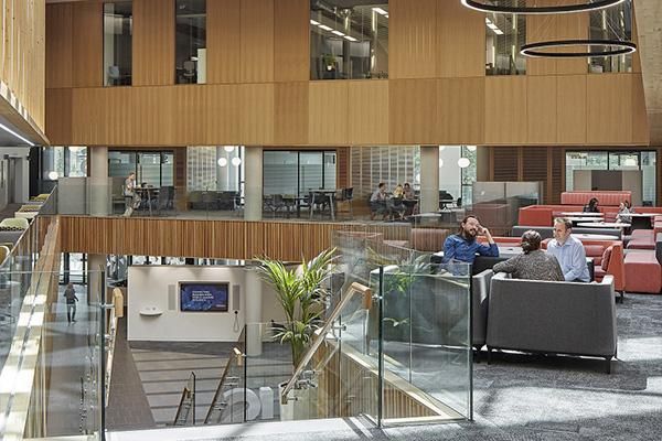 People sitting on chairs in groups inside the Nexus building