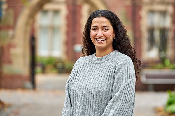 Portrait of Pragya Sharma, smiling in front of Clothworker's Court.