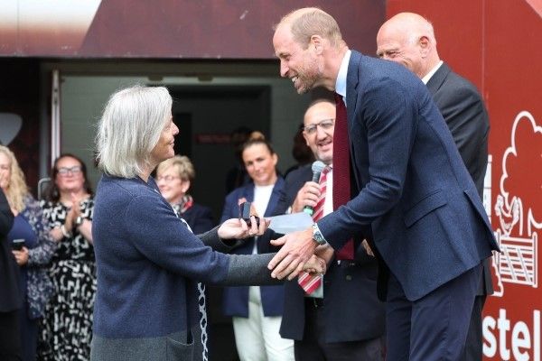 Suzanne Glavin shaking hands with HRH Prince of Wales and recieving her brooch.