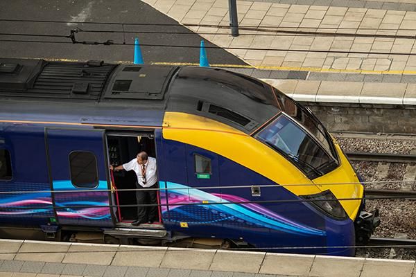 Driver of Class 180 train looks out of door on platform at Leeds railway station