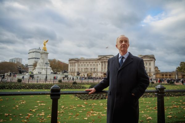 Nicholas Witchell stands before Buckingham Palace