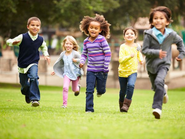 Five children running in a field.