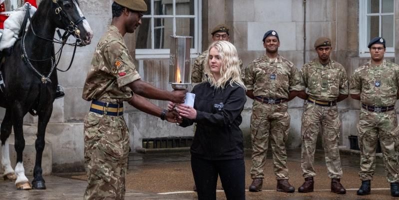 Student Eleanor Dufton is seen receiving the legacy torch from a soldier at the Horse Guards Parade.