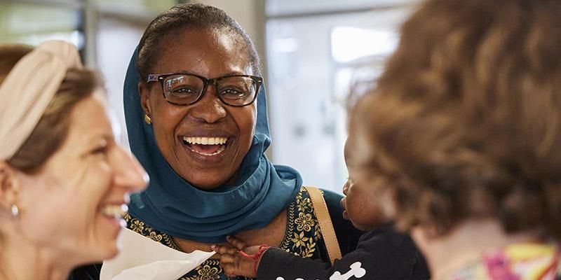 Three people chatting and smiling at an Adult Learner Summer School