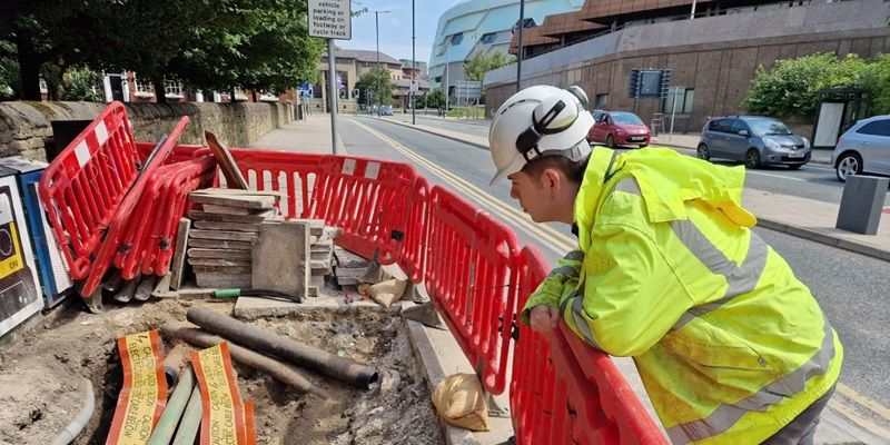 Apprentice Alex checking work on a Leeds city centre footpath to remediate cracked flagstones and uneven ground.