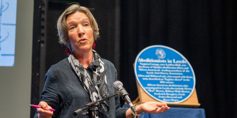 Professor Bridget Bennett gives a speech with the blue plaque in the background