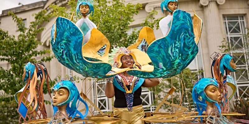 Woman wearing cold and turquoise carnival costume with Afrofuturism theme