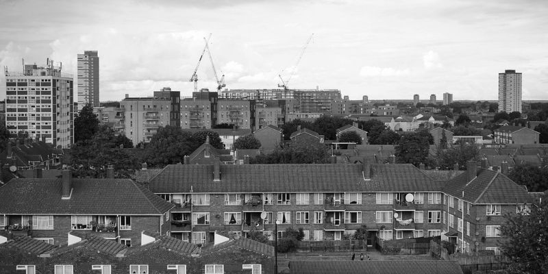 A black and white picture of an urban skyline featuring multiple blocks of flats