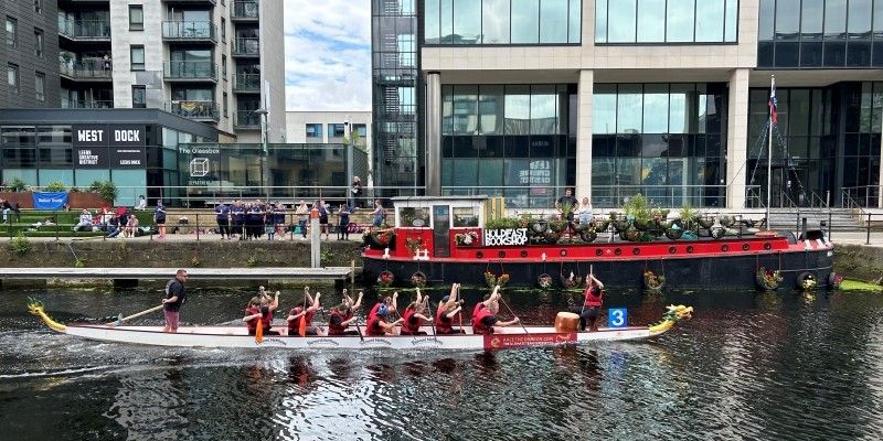 A group of 15 people taking part in a Dragon Boat race at Leeds Dock.