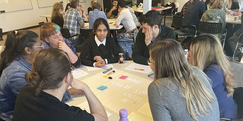 Students and staff sat around a table at a design sprint