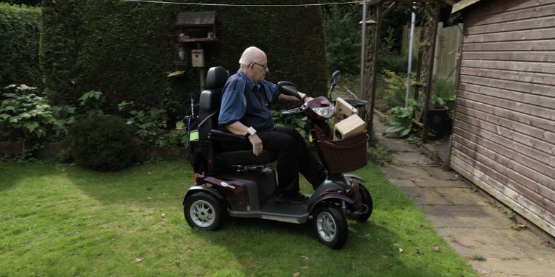 82-year-old Colin uses the echome device with his mobility scooter in his garden