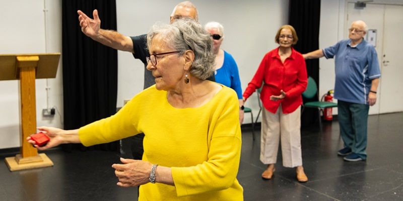 A group of older people taking part in a dance or movement activity