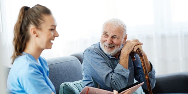 A care worker laughing with an elderly patient