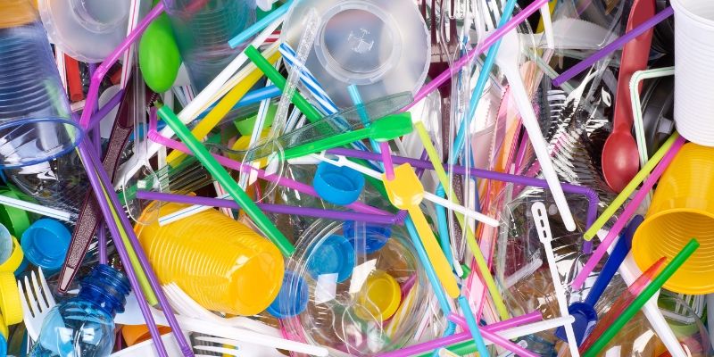 a pile of brightly coloured plastic like forks, spoons, cups, bottle lids