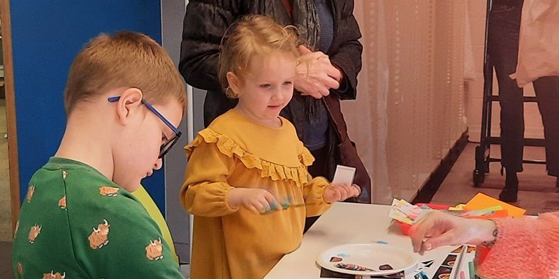 Two small children doing craft activities.