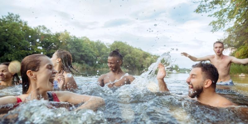 Group of friends in their 20s having fun in a river
