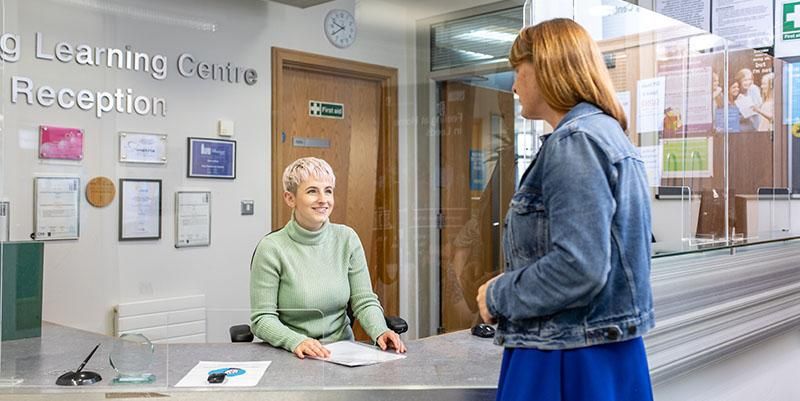 A member of staff talking to a mature student at the Lifelong Learning Centre