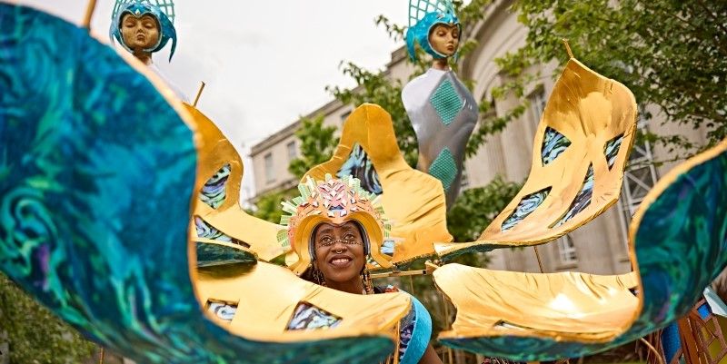 A person wearing a blue and yellow mechanical style costume and headwear. 