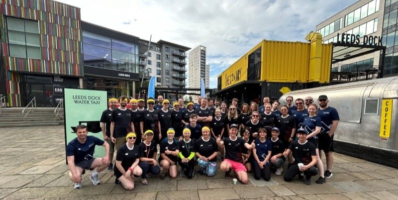 A large group of people smiling for the photo at Leeds Dock